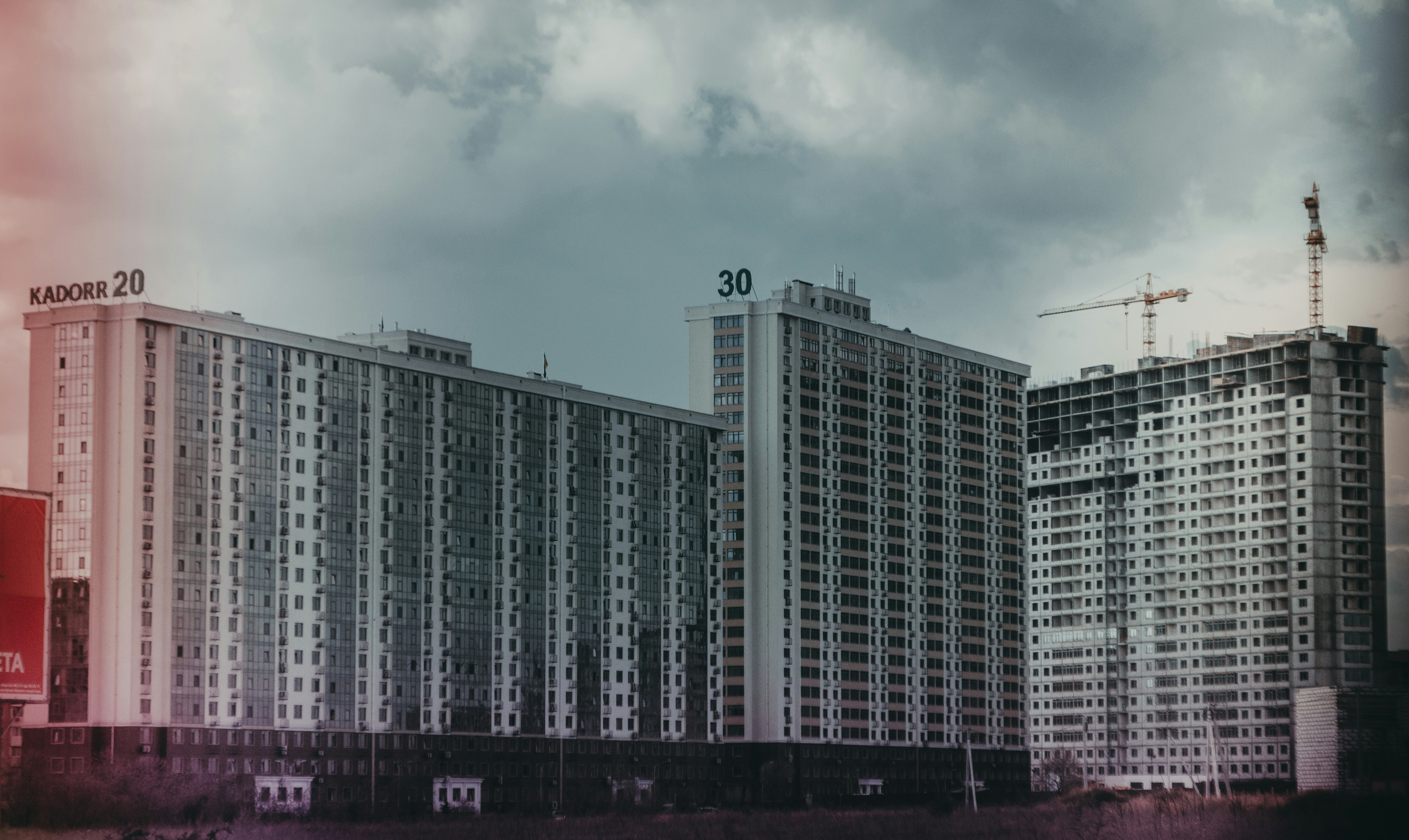 自動車のECU開発現場で、エンジニアが複数のモニターを見ながら、リアルタイムOSモニタリングツールのグラフ表示を確認している様子